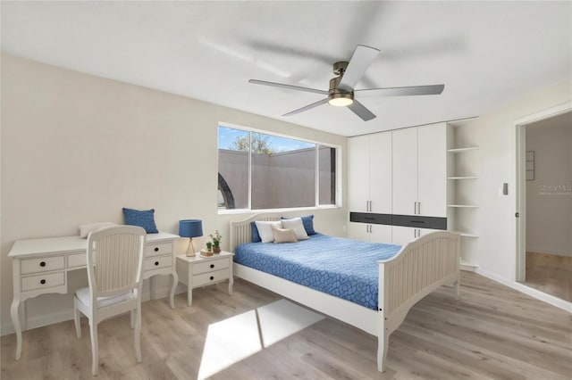 bedroom featuring baseboards, light wood-type flooring, and a ceiling fan