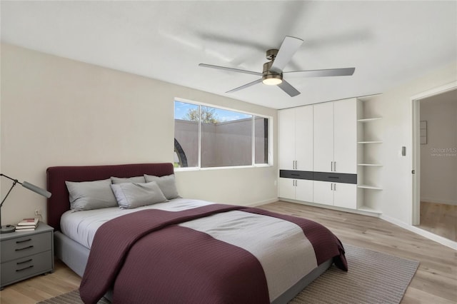 bedroom featuring a ceiling fan, light wood-type flooring, a closet, and baseboards