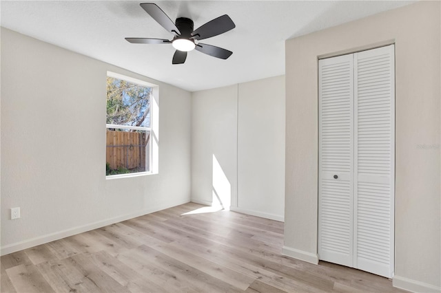 unfurnished bedroom with a closet, a ceiling fan, baseboards, and wood finished floors