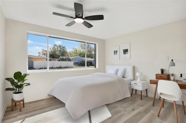 bedroom featuring ceiling fan, baseboards, and light wood-style flooring