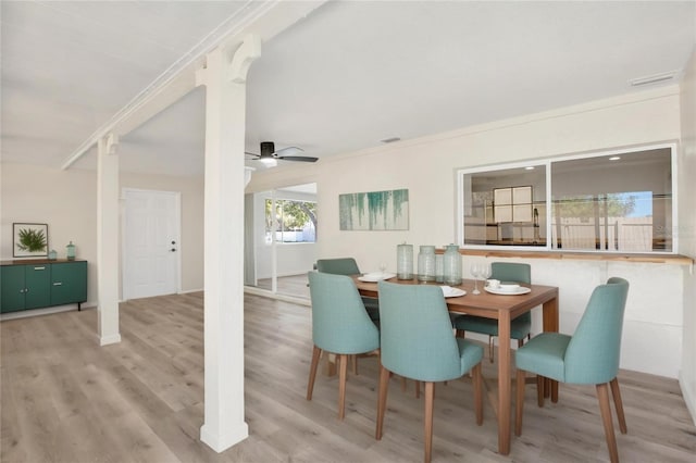 dining room with crown molding, visible vents, light wood-type flooring, and ceiling fan