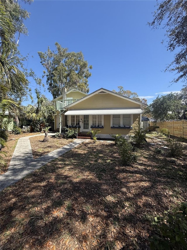 rear view of property featuring fence