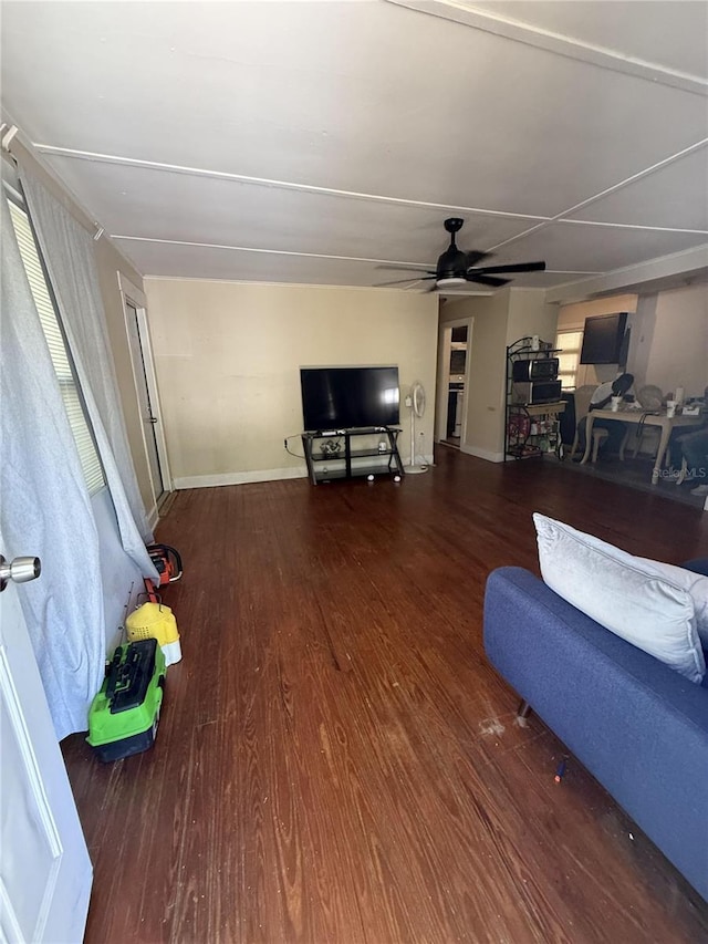 living room featuring baseboards, a ceiling fan, and wood finished floors