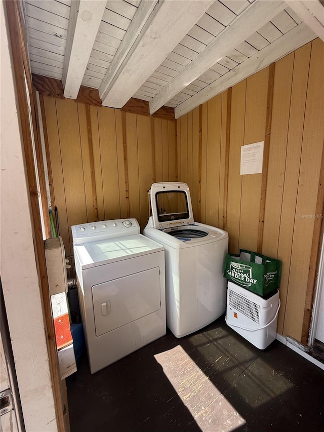 washroom with wooden walls, washer and dryer, and laundry area