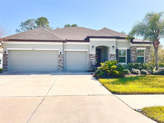 view of front of home with stucco siding, stone siding, a garage, and driveway