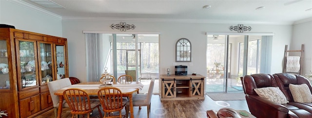 dining room with a ceiling fan, wood finished floors, and crown molding