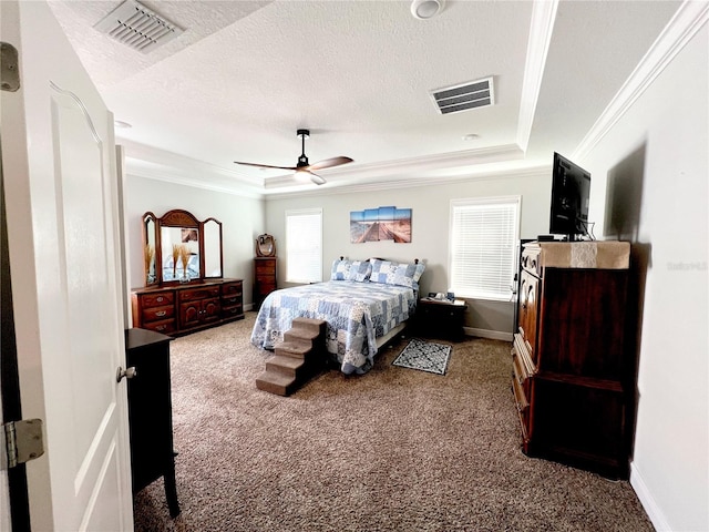 carpeted bedroom with visible vents, crown molding, and a tray ceiling