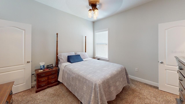 bedroom featuring light carpet, a ceiling fan, and baseboards