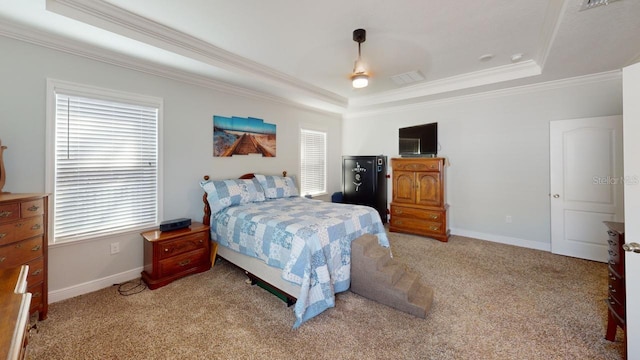 bedroom with light colored carpet, a raised ceiling, and baseboards