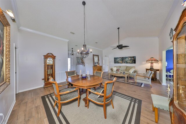 dining space featuring vaulted ceiling, crown molding, and wood finished floors