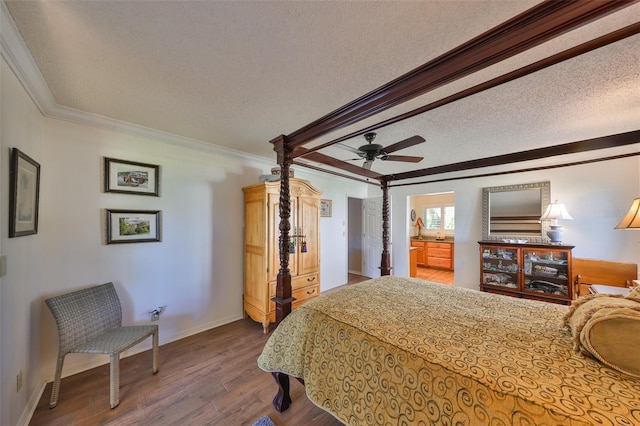 bedroom featuring a ceiling fan, a textured ceiling, crown molding, baseboards, and dark wood-style flooring