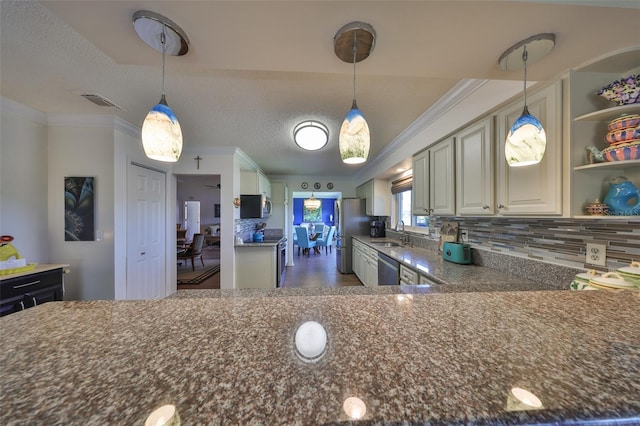 kitchen with decorative light fixtures, ornamental molding, appliances with stainless steel finishes, and a sink