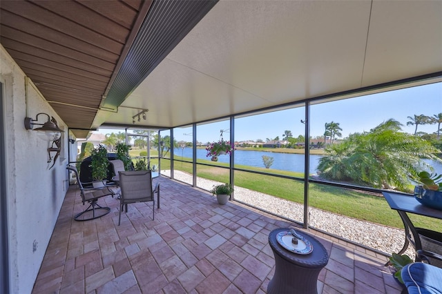 unfurnished sunroom featuring a water view