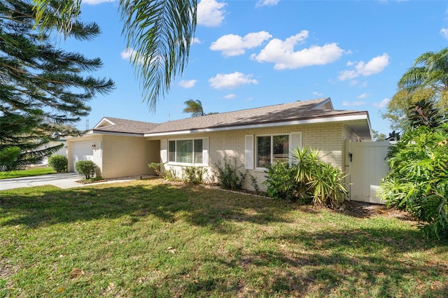 ranch-style house featuring brick siding, an attached garage, driveway, and a front yard