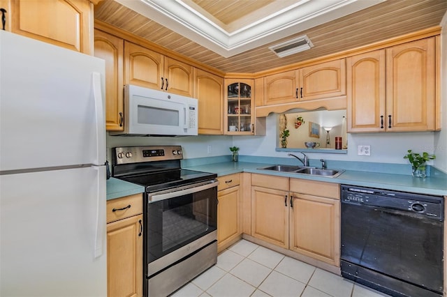 kitchen featuring glass insert cabinets, light brown cabinetry, light tile patterned floors, white appliances, and a sink