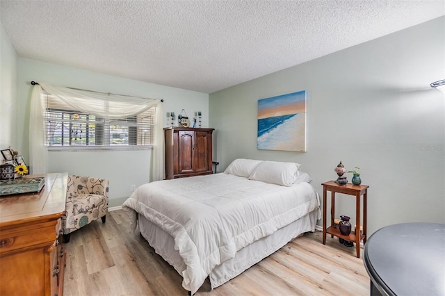 bedroom featuring a textured ceiling and light wood-type flooring