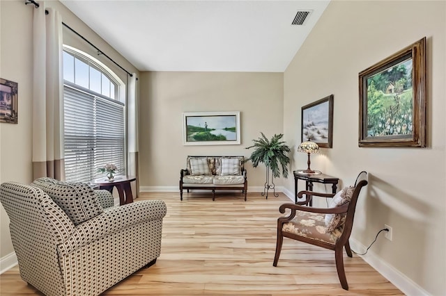 living area with visible vents, baseboards, and light wood-style flooring