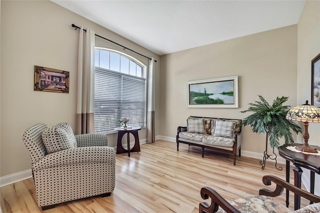 living area with baseboards and light wood finished floors