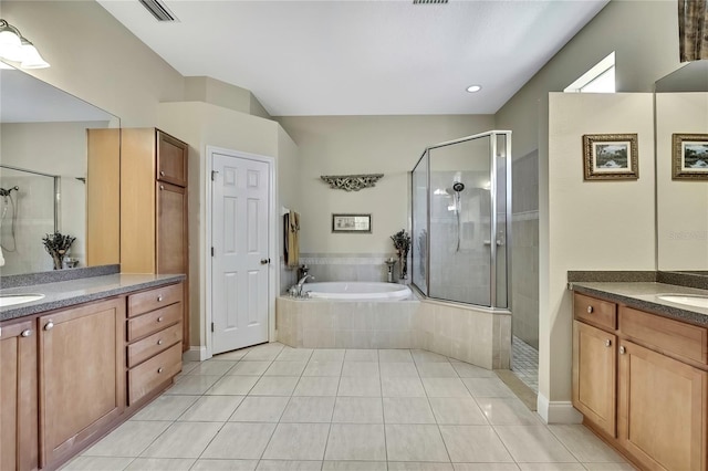 full bathroom featuring tile patterned floors, visible vents, two vanities, a stall shower, and a bath