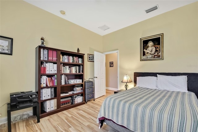 bedroom featuring visible vents, light wood-style flooring, and baseboards