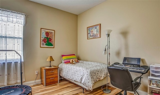 bedroom featuring baseboards and light wood-style floors