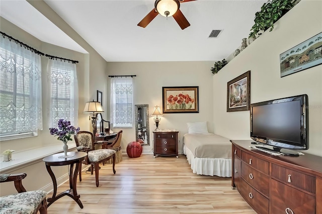 bedroom featuring visible vents, lofted ceiling, light wood-style floors, and a ceiling fan