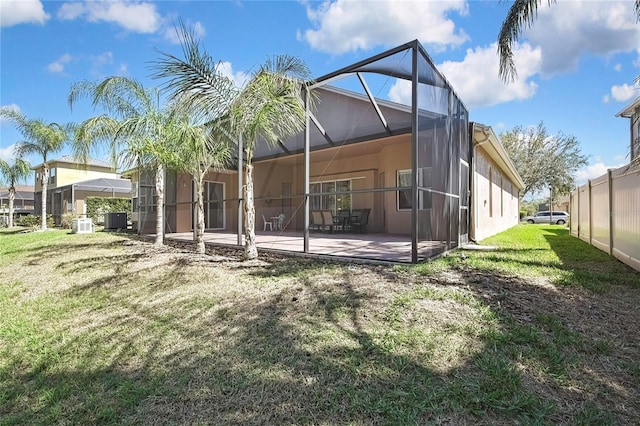 back of house with stucco siding, a patio, cooling unit, a yard, and a lanai