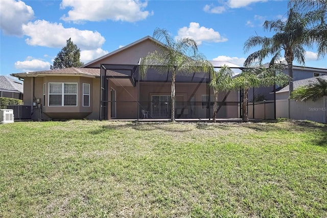 back of house with fence, central air condition unit, stucco siding, a lawn, and glass enclosure