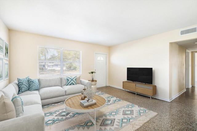 living area with speckled floor, baseboards, and visible vents