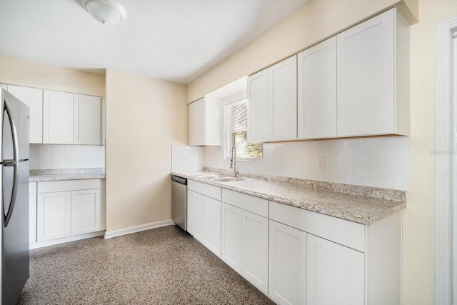 kitchen with light countertops, decorative backsplash, appliances with stainless steel finishes, white cabinets, and a sink