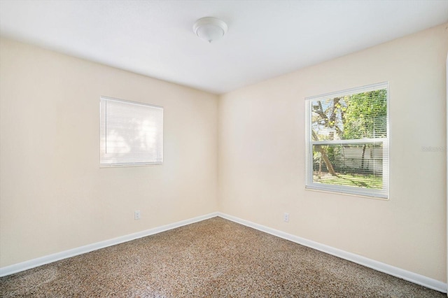 empty room with speckled floor and baseboards