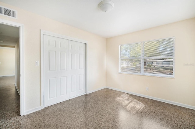 unfurnished bedroom featuring baseboards, visible vents, and a closet