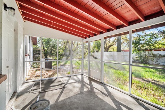 unfurnished sunroom featuring lofted ceiling with beams