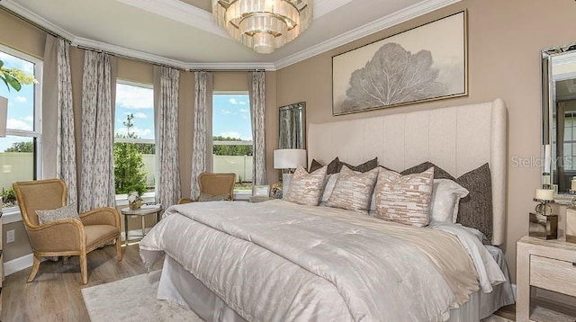 bedroom featuring a notable chandelier, crown molding, and wood finished floors