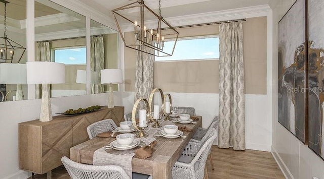 dining room with an inviting chandelier, wood finished floors, baseboards, and ornamental molding