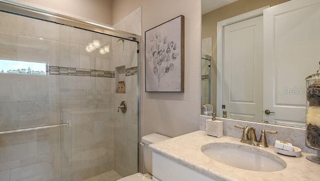 full bath featuring vanity, toilet, and a shower stall