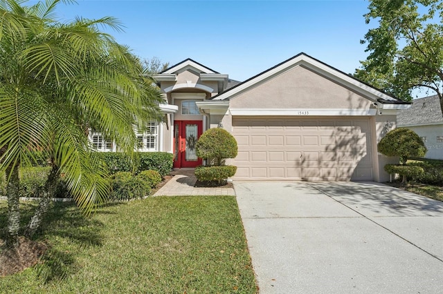 view of front of property with concrete driveway, a front lawn, a garage, and stucco siding