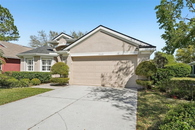 view of front of property with a garage, driveway, and stucco siding