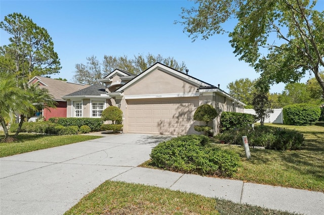 view of front of property featuring stucco siding, an attached garage, concrete driveway, and a front lawn