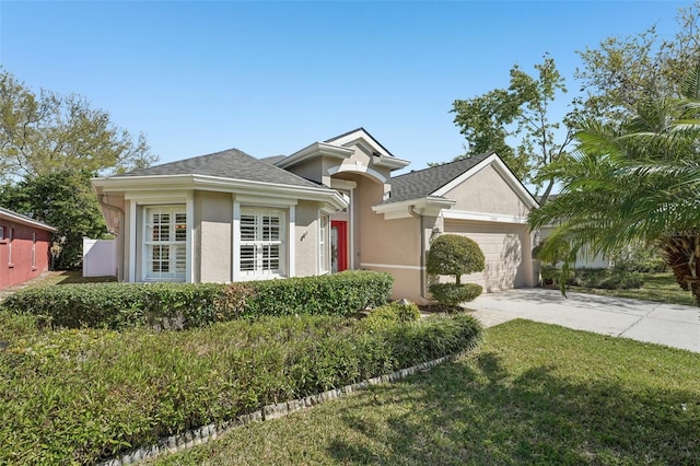 view of front of property with an attached garage, a shingled roof, stucco siding, concrete driveway, and a front lawn