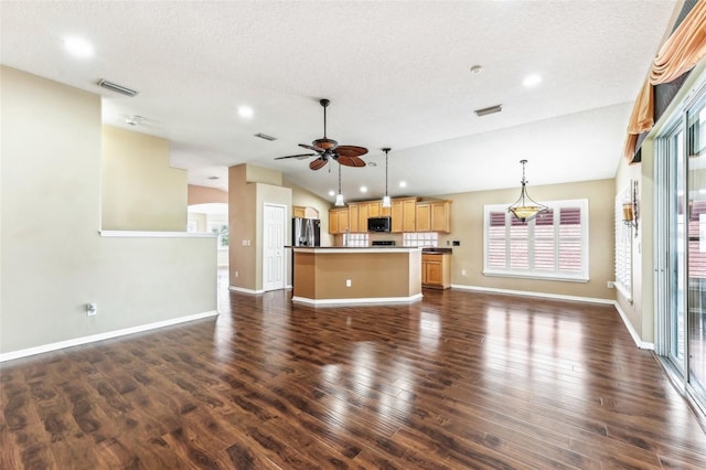 unfurnished living room featuring vaulted ceiling, a ceiling fan, dark wood-style flooring, and baseboards