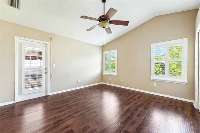 empty room with wood finished floors, baseboards, visible vents, ceiling fan, and vaulted ceiling