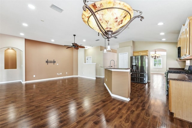 kitchen with stainless steel appliances, arched walkways, dark wood-type flooring, and visible vents