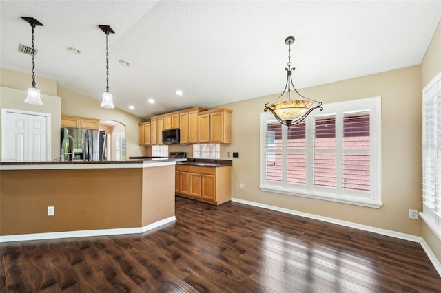 kitchen featuring dark countertops, visible vents, lofted ceiling, stainless steel fridge, and dark wood-style flooring