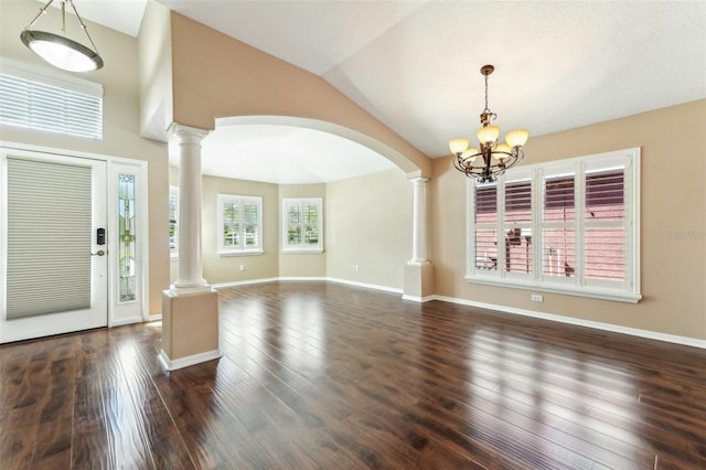 foyer with dark wood-style flooring, ornate columns, and a chandelier