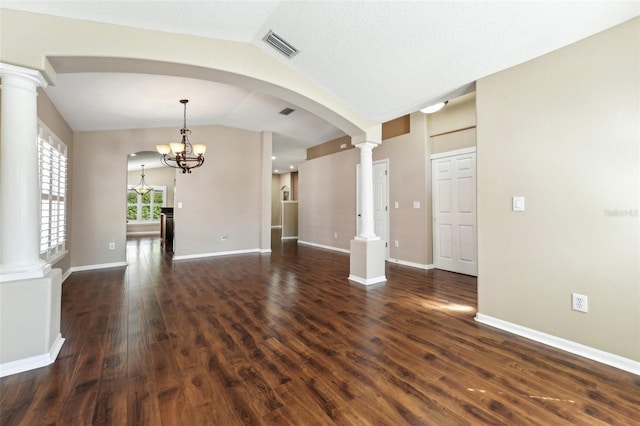 interior space with visible vents, lofted ceiling, dark wood-style floors, a notable chandelier, and ornate columns