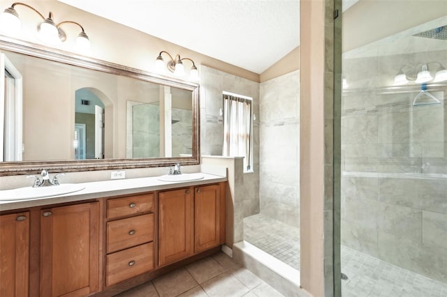 full bath with a shower stall, vaulted ceiling, tile patterned floors, and a sink