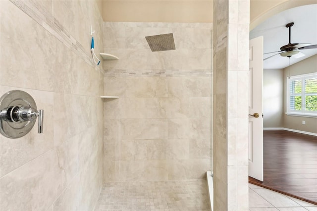 bathroom featuring tile patterned floors, tiled shower, baseboards, and ceiling fan