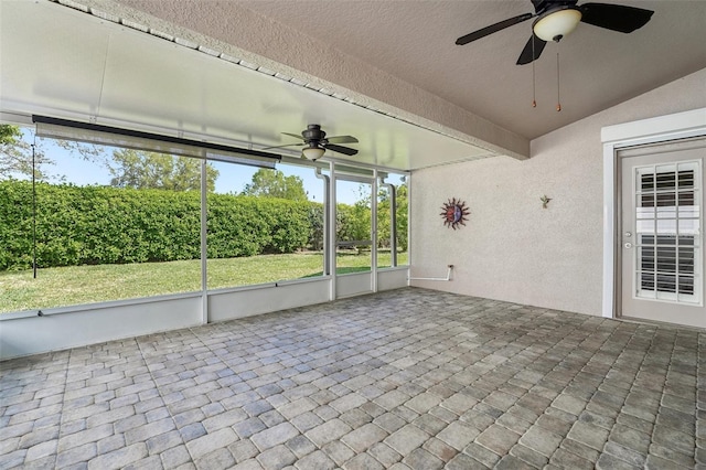 unfurnished sunroom featuring beam ceiling and ceiling fan