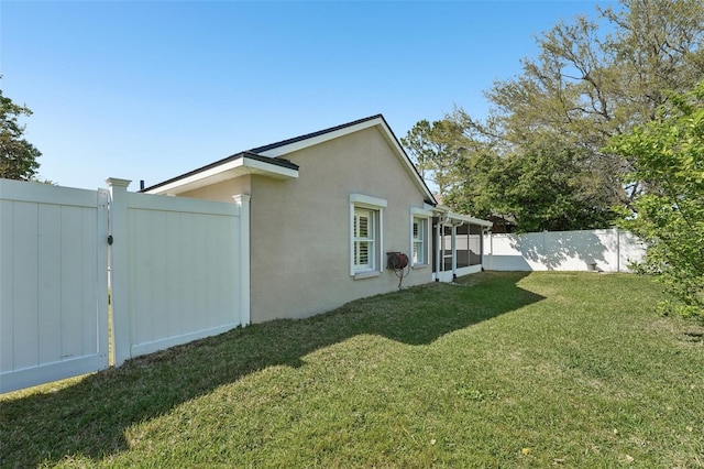 exterior space featuring a yard, a fenced backyard, and stucco siding